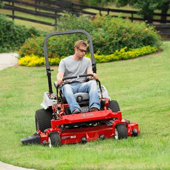 Professional landscaper mowing lawn with an 60-inch Lazer Z E-Series riding mower