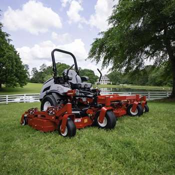 Lazer Z X Series 96-In mower on a field of grass in front of a pond and white picket fence.