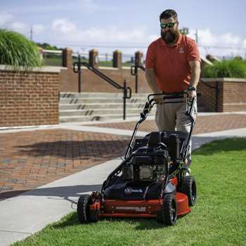 Landscape Pro using an Exmark Commercial 30 X-Series mower to cut grass next to a paved trail.