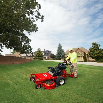 Landscaper mowing grass with a Turf Tracer X-Series mower.